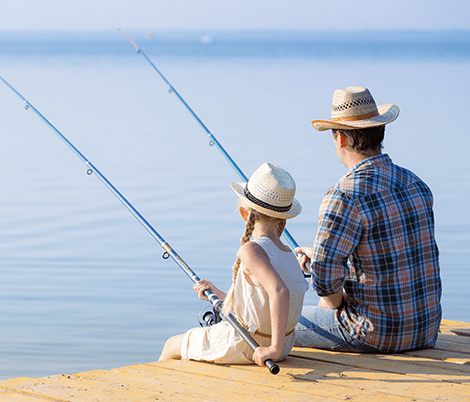A man and woman fishing on the dock.